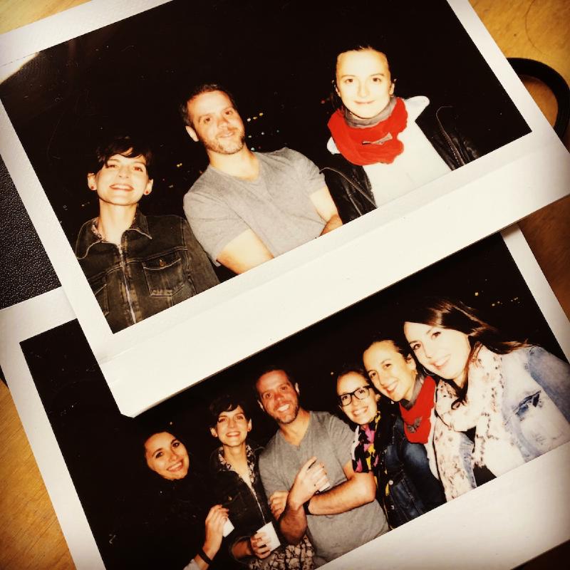 Two instant-film prints on a wooden table showing groups of smiling friends posing at night in France