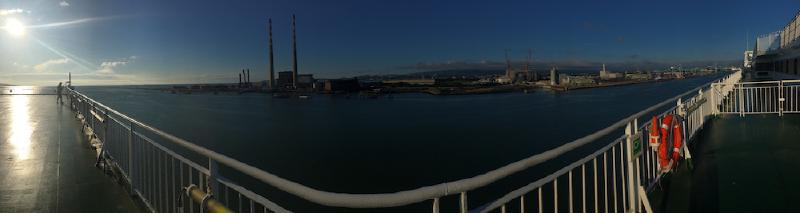 Dublin Bay from a ferry deck, the twin striped Poolbeg chimneys and port cranes low on the horizon