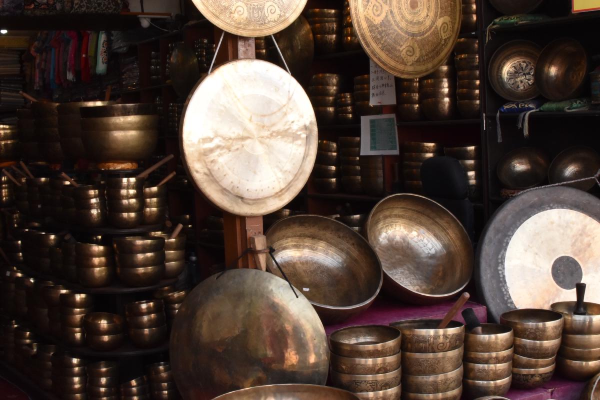 Kathmandu shop crammed with stacked brass singing bowls and large hanging gongs in every size